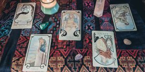 Fünf Tarot-Karten von links nach rechts: As der Münzen, Zwei der Stäbe, Königin der Schwerter, die Gerechtigkeit, Fünf der Schwerter